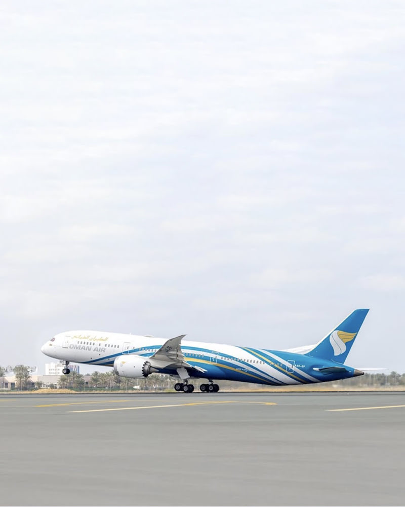 Oman Air Boeing 787 aircraft taking off from the runway on a clear day