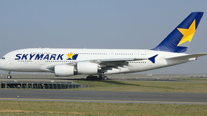 Skymark Airlines aircraft on the runway with the airline's logo and yellow star on the tail.