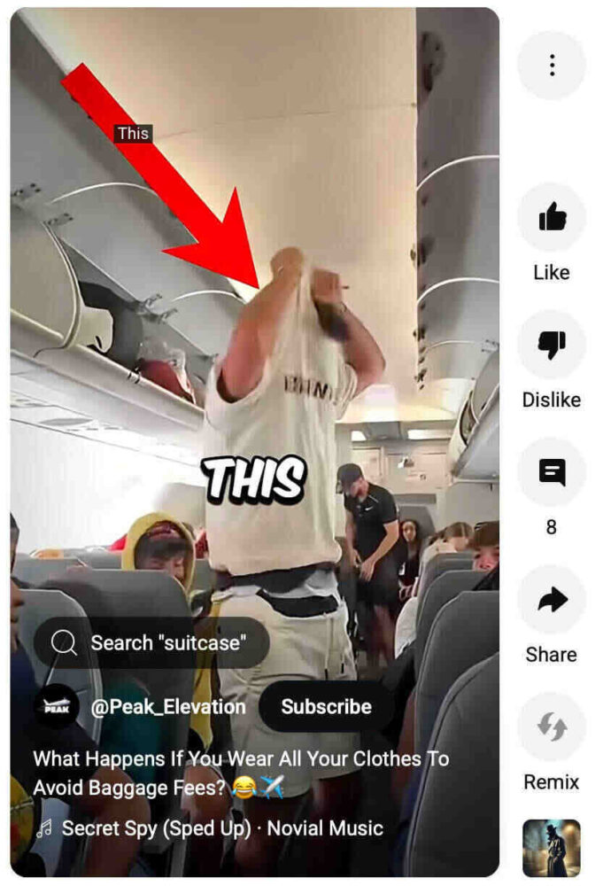 Passenger on an airplane taking off  extra layers of clothing from a suitcase to avoid paying baggage fees.