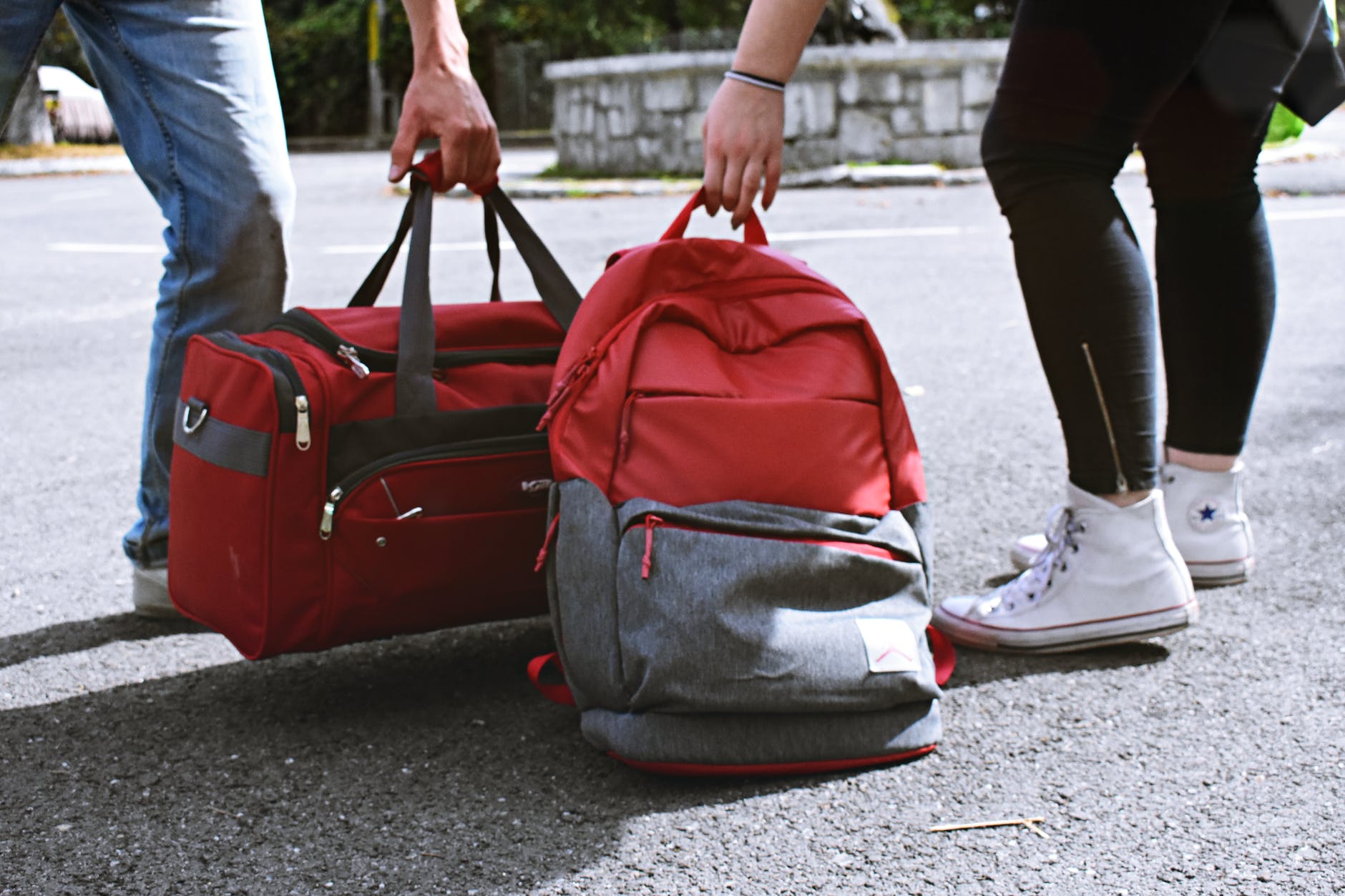 two person carrying duffel and backpack