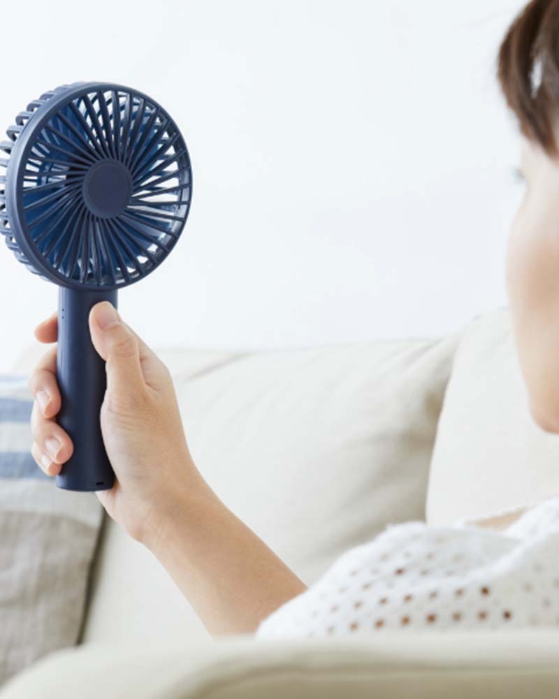 Women using a fan with right hand  