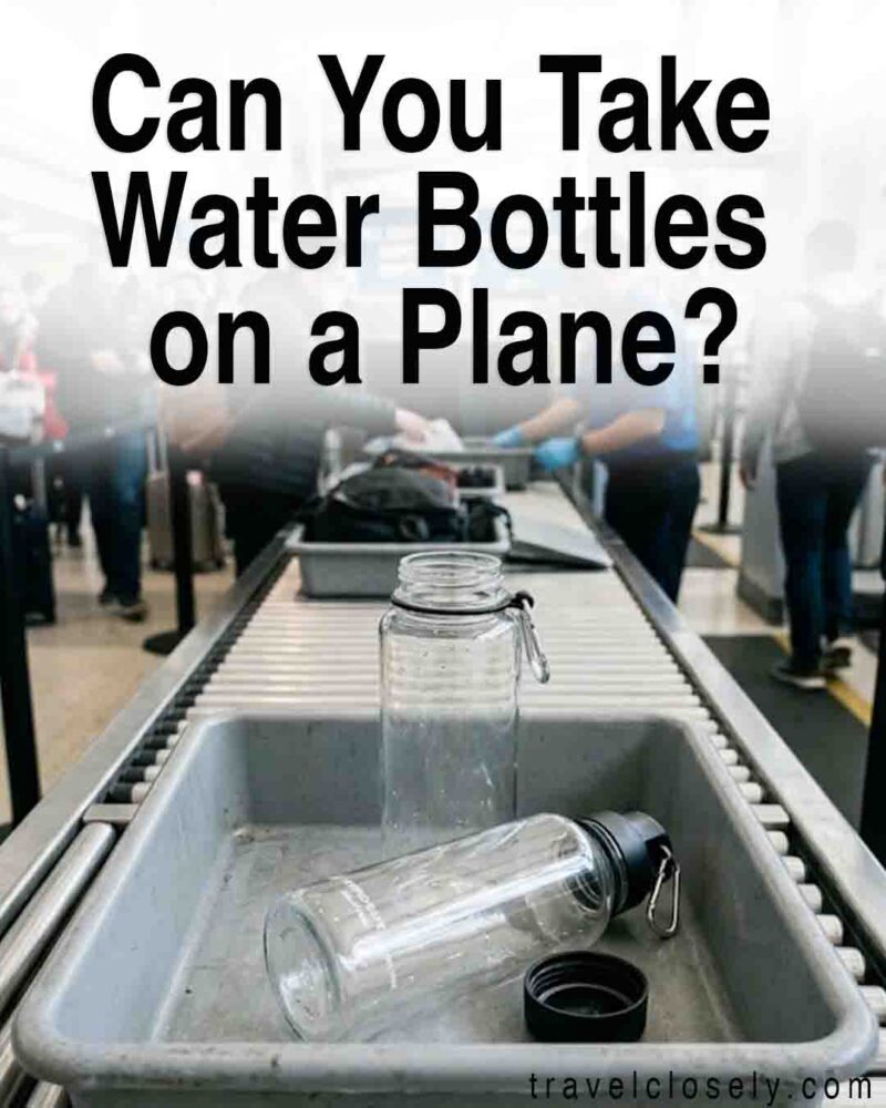 Empty reusable water bottles in a TSA security bin on an airport screening conveyor belt