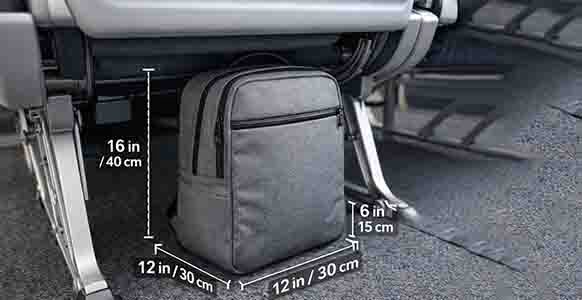 Carry-on backpack under an airplane seat with labeled size measurements